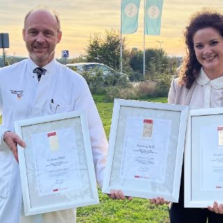 Professor Dr. Heiko Graichen und Jana Humrich mit den nächsten Güte-Siegeln, welche die Foyer-Wand der Klinik zieren werden.