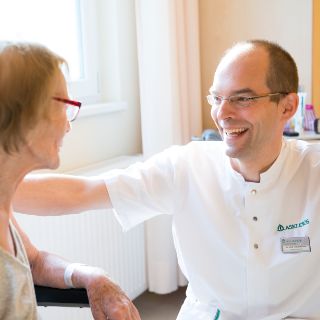 Das Bild zeigt Herrn Richter im Gespräch mit einer geriatrischen Patientin